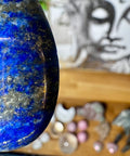 Close-up of a blue stone with a blurred background featuring a face and various objects.
