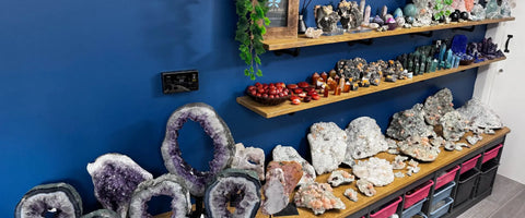 Mineral and crystal collection displayed on shelves against a blue wall.