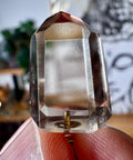 Citrine  Clear crystal held between fingers with a blurred background