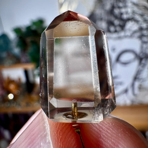 Citrine  Clear crystal held between fingers with a blurred background
