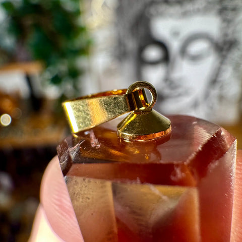 Gold pendant citrine on a blurred background