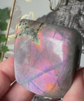 Video of Pink Labradorite freeform with purple fractures, orange glow, and gold-green shimmer – Crystals & Reiki.